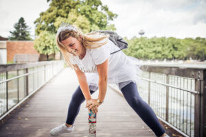 Die Braut lacht ausgelassen während einer spaßigen Aktivität beim Junggesellinnenabschied auf einer Brücke